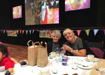 Staff member and resident smiling for the camera while at the Tea Dance