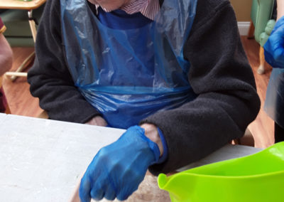 Male resident at Princess Christian flouring a tray during cooking club