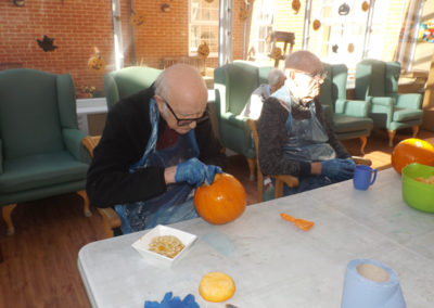 Princess Christian Care Home resident carving a Halloween pumpkin