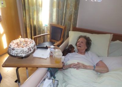 Female resident at Princess Christian Care Home receiving a special birthday cake in her room