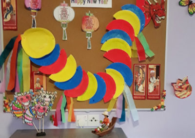 A Chinese Dragon made from colourful paper plates displayed on a pin board at Princess Christian Care Home