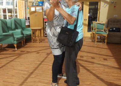 A staff member and resident dancing together
