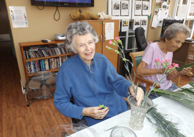 A lady resident placing flowers in a vase