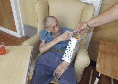 Male resident at Princess Christian being presented with a gift by the Activities Coordinator for Fathers Day