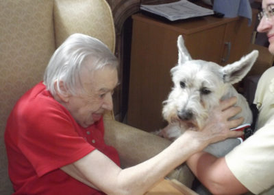Female resident at Princess Christian stroking Billy the Pet Therapy dog