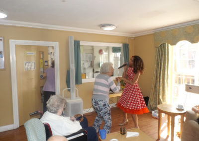 Female resident at Princess Christian dancing with singer in the lounge