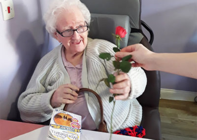 Lady resident receiving a single red rose at Princess Christian Care Home