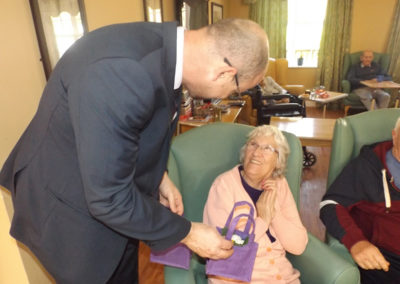 Lady smiling as she receives a Mother's Day flower basket at Princess Christian Care Home