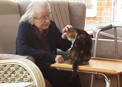 Princess Christian residents sitting indoors stroking their cat