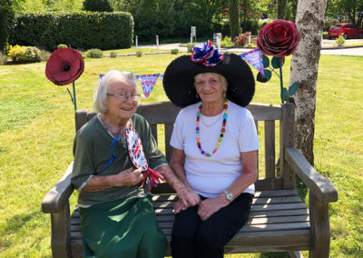 Two Princess Christian Care Home residents enjoying the sunny front garden on VE Day 2020