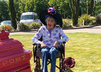Princess Christian Care Home resident enjoying the sunny front garden on VE Day 2020 wearing large sunhat