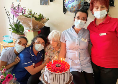 Princess Christian Care Home resident with staff and her birthday cake