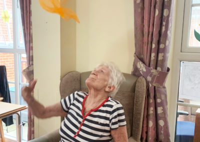 Princess Christian Care Home resident throwing a prop scarf in the air